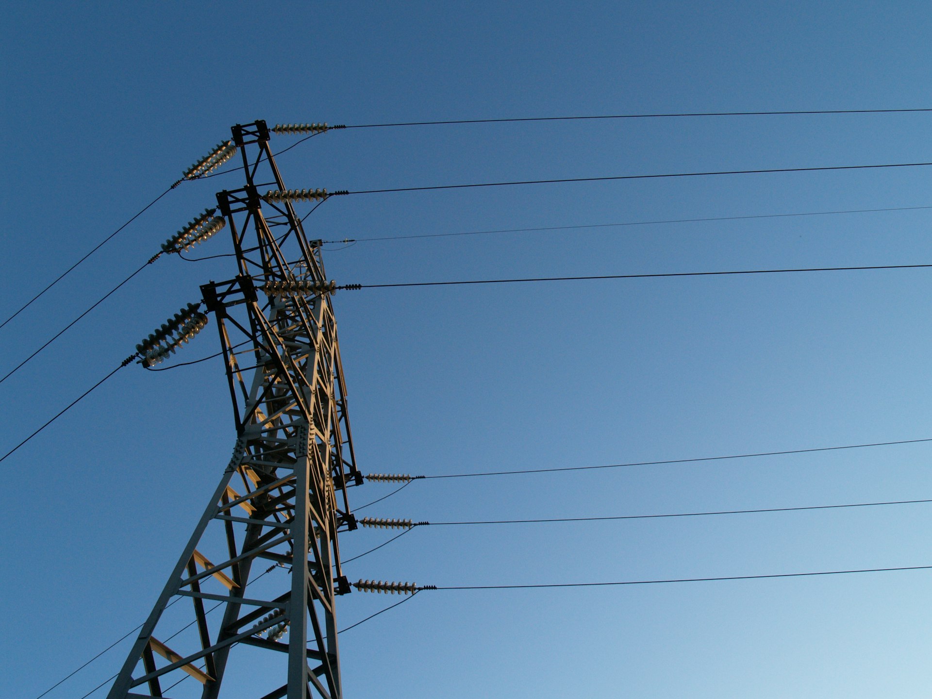 High-voltage transmission tower against a clear blue sky